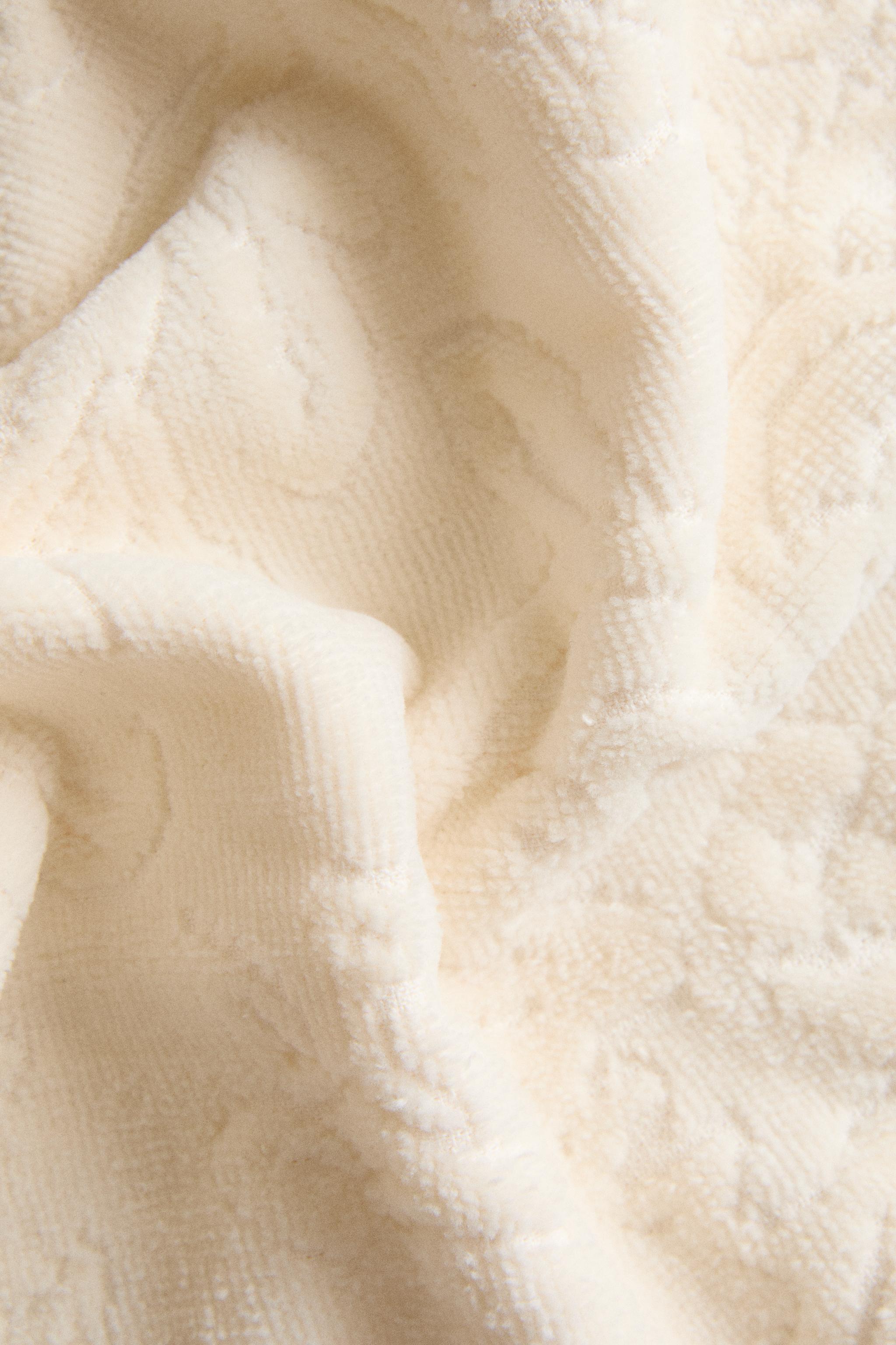 SERVIETTE DE BAIN POMPONS JACQUARD